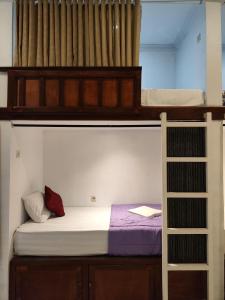 Ega S Hostel في نوسا بينيدا: غرفة نوم بسريرين بطابقين وسلم