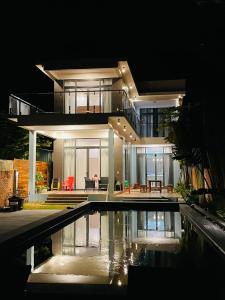 une maison avec une piscine la nuit dans l'établissement Khalid’s House at the East coast, à Duong Dong