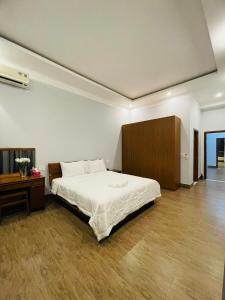 - une chambre avec un grand lit et une armoire en bois dans l'établissement Khalid’s House at the East coast, à Duong Dong