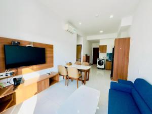 頭頓的住宿－Mermaid Seaview Apartment Vung Tau，一间带蓝色沙发的客厅和一间用餐室