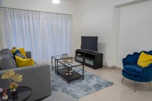 een woonkamer met een bank, een tv en 2 stoelen bij Torre Sky 01 - Apto. J9 in Santo Domingo