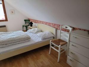 ein Schlafzimmer mit einem Bett und einem Stuhl darin in der Unterkunft Villa Merlimont, 5 pièces, 10 personnes - FR-1-672-31 in Merlimont