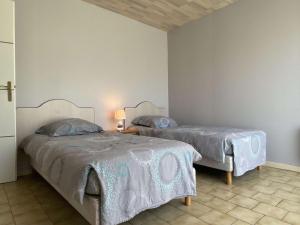 een slaapkamer met 2 bedden en een wit dekbed bij Maison Saint-Pierre-d'Oléron, 3 pièces, 4 personnes - FR-1-246A-292 in Saint-Pierre-dʼOléron