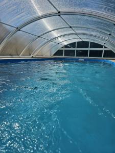 una piscina de agua azul con estructura metálica en schönes Ferienhaus mit grossem Pool 4 km zum Balaton, en Balatonszentgyörgy