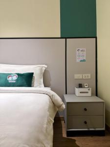 a bedroom with a bed with a green and white headboard at PENTAFIELD CITY RESIDENCE in Amphoe Phra Khanong
