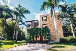 a brick building with palm trees in front of it at Modern Condo in Casa de Campo in La Romana