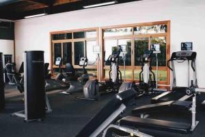 a gym with rows of treadmills and elliptical machines at Modern Condo in Casa de Campo in La Romana