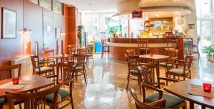 restauracja ze stołami i krzesłami oraz bar w obiekcie Apartman Hotel w mieście Bük