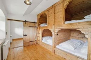 two bunk beds in a room with wooden walls at Gemütliches Ferienhaus in Tannenberg mit Grill, Terrasse und Garten in Burggen