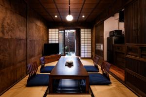 uma sala de jantar com uma mesa de madeira e cadeiras em Rinn Shijo Machiya em Quioto