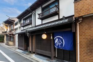 a building with a blue and white sign on it at Rinn Shijo Machiya in Kyoto