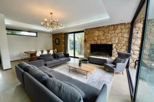 ein Wohnzimmer mit Sofas und einem Steinkamin in der Unterkunft La Serenite Villa Deluxe in Yukarıkaraman