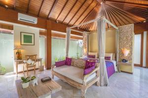 a bedroom with a canopy bed in a room at The Royal Purnama - Adults Only in Keramas