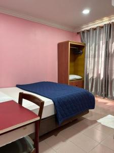 Hotel Cahaya في تانجونج ماليم: غرفة نوم بسرير وكابينة وطاولة