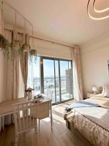 Azizi Aura 1013 في دبي: غرفة نوم مع مكتب وسرير ونافذة