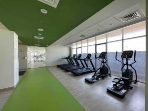 a gym with a row of treadms and elliptical machines at Azizi Aura 1013 in Dubai