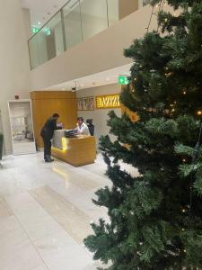 een kerstboom in de lobby van een winkel bij Azizi Aura 1013 in Dubai