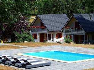 una casa con piscina frente a una casa en Gemütliche BERGHüTTE-2 am Bach mit Zugang zur Sauna, heißen Badewanne und Pool en Szklarska Poręba