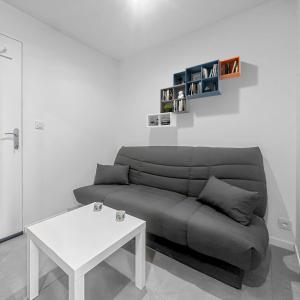 ein Wohnzimmer mit Sofa und Tisch in der Unterkunft Le Petit Torcieu in Torcieu