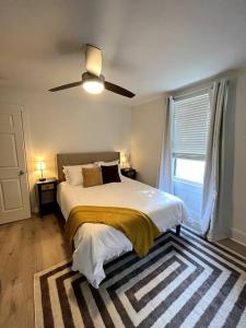 een slaapkamer met een bed en een plafondventilator bij Veteran Owned Retreat with Games in Baton Rouge