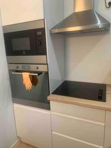 una cucina con piano cottura e forno a microonde di Maison des Larris a Beauvais