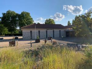 ein weißes Gebäude mit einem Schild mit der Aufschrift Arma in der Unterkunft Le Petit Torcieu in Torcieu