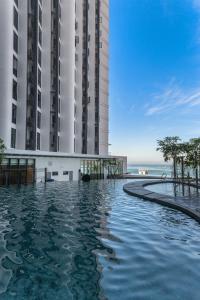 a swimming pool in front of two tall buildings at Grace Suite @ The Shore KK in Kota Kinabalu