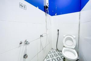 a bathroom with a toilet with a hose at Citara Jaya Guesthouse Mitra RedDoorz in Bekasi