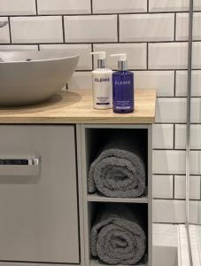 a bathroom vanity with two bottles of soap and towels at Elegant, Luxury Family Apartment! Marlow Town Centre, Walk to Pubs in Buckinghamshire