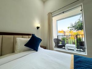 a bedroom with a bed and a large window at Golden Mango By Food Bunglow in Rāmnagar
