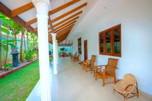 a porch of a house with chairs and a table at The Islands Breeze Villa in Dehiwala