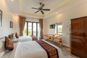 um quarto de hotel com duas camas e uma mesa em Rice River Villa - Hoi An em Hoi An