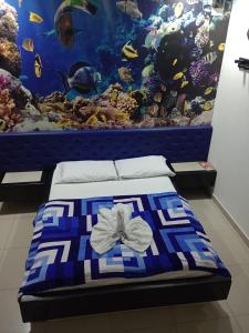 ein Bett mit einer blauen und weißen Decke und einem Aquarium in der Unterkunft Hotel Country Medellin in Medellín