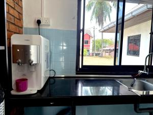 una macchinetta del caffè su un bancone accanto a un lavandino di The Wooden Retreat by Elite Stay a Port Dickson