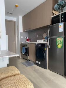a kitchen with a washer and dryer in a kitchen at Indigo beach residence 110 in Sharjah