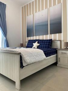 a bedroom with a large bed with blue pillows at Indigo beach residence 110 in Sharjah