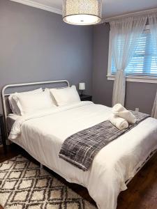 a bedroom with a large white bed with a window at Peaceful 4BDRM Home 5mins to Clifton Hill in Niagara Falls