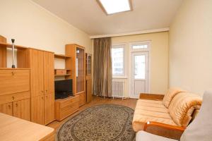 a living room with a couch and a tv at south of Bayangol Hotel, 1 bedroom apartment 25-58 in Ulaanbaatar