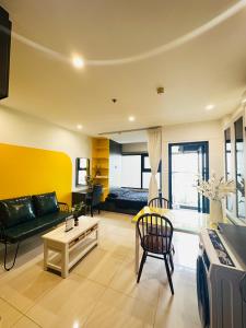 - un salon avec un canapé et une table dans l'établissement Vinhomes Grand Park Studio Apartment Ho Chi Minh City, à Long Bình