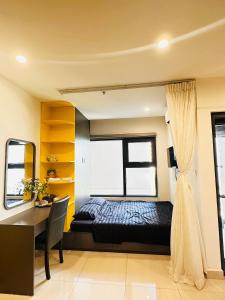 - une chambre avec un lit, un bureau et une fenêtre dans l'établissement Vinhomes Grand Park Studio Apartment Ho Chi Minh City, à Long Bình