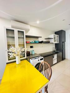 une table jaune dans une cuisine avec un comptoir jaune dans l'établissement Vinhomes Grand Park Studio Apartment Ho Chi Minh City, à Long Bình
