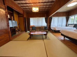 a living room with a couch and a bed at Guest House Renga in Henza