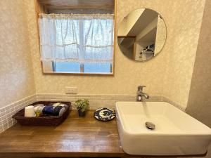een badkamer met een wastafel en een spiegel bij Guest House Renga in Henza
