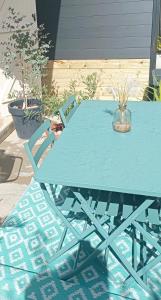 a blue picnic table with two chairs around it at Narbonne Studio Lamarobile avec jardin et terrasse proche des Grands Buffets, du centre ville et de la gare in Narbonne