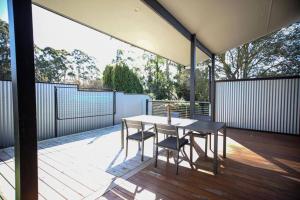 a patio with a table and chairs on a deck at Rail View Stay Timboon in Timboon