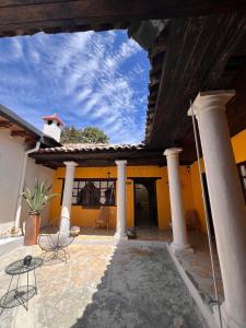 a patio with chairs and a yellow house at Chunca Casa-Hostal boutique in San Cristóbal de Las Casas