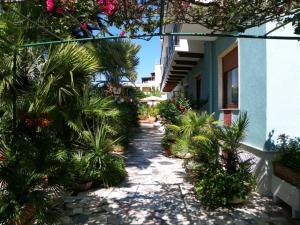 un cortile con palme e un edificio di Hotel La Playa ad Alghero