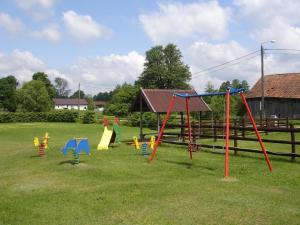 um parque infantil com equipamento de brincar colorido num campo em Kleine gemütliche Wohnung mit überdachter Terrasse em Lukta