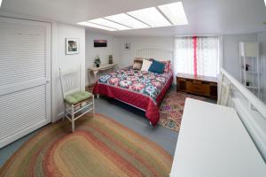 een slaapkamer met een bed, een tafel en een tapijt bij Carriage House in Denver