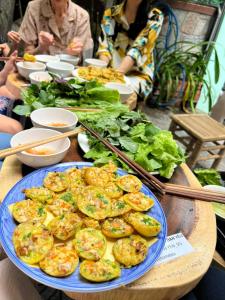 a table with a blue plate of food on it at Home Tea An Yên Dorm in Ho Chi Minh City